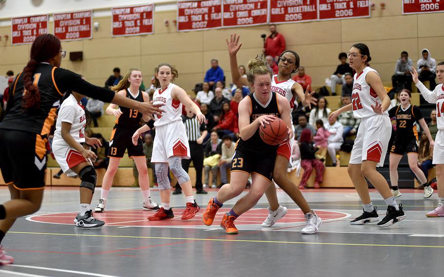 Spangdahlem's Lizzie Koenig fights in the low block with Kaiserslautern's Hazel Sanders while Sentinel teammate Gabby Schmidt, left, offers to receive a pass during Friday evening's game at Kaiserslautern High School in Kaiserslautern, Germany. The Raiders defeated the Sentinels 35-8.