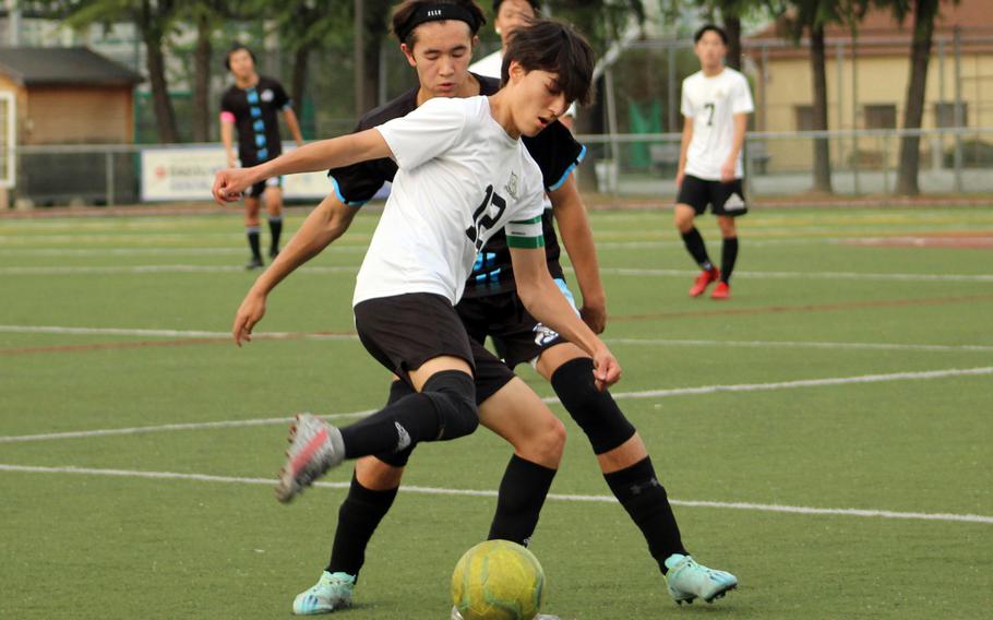 Daegu’s Beckam Clites plays the ball in front of Osan‘s Chris Hinchliffe during Friday’s DODEA-Korea boys soccer match. The Warriors won 4-1.