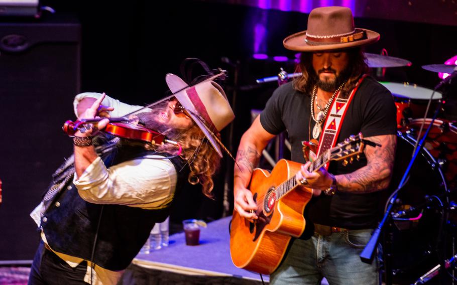 The country music duo War Hippies — Marine veteran and guitarist Scooter Brown, right, and Army veteran and violinist Donnie Reis, left — perform March 9, 2023, at MadLife Stage & Studios in Woodstock, Ga., just north of Atlanta. Brown and Reis served in Iraq before embarking on music careers after leaving the military.