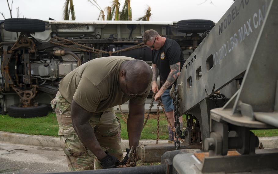 Airmen work on a government vehicle flipped by Typhoon Mawar at Andersen Air Force Base, Guam, Friday, May 26, 2023.