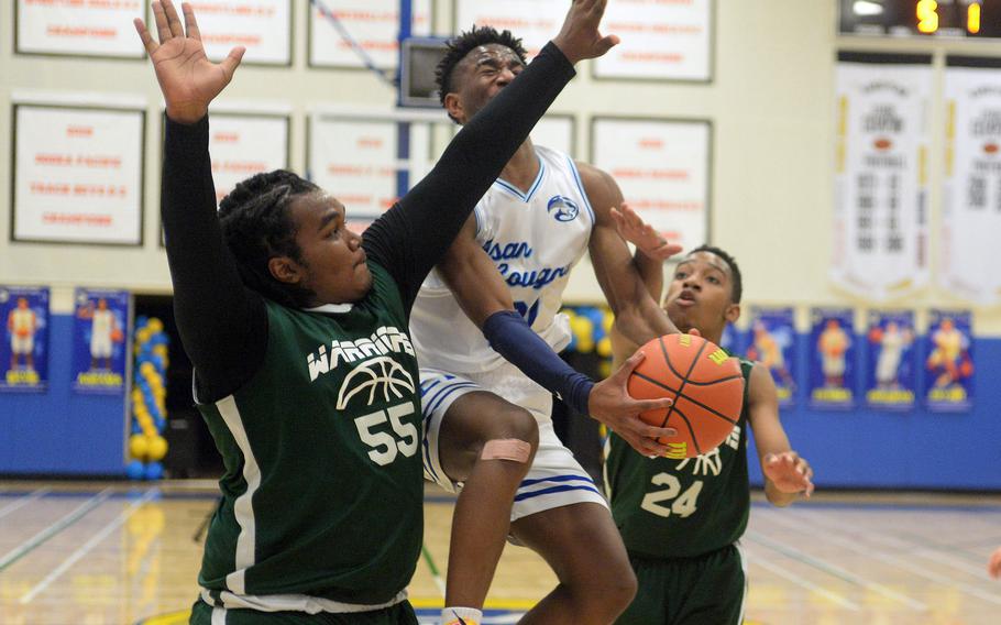 Osan's Justiss Parker-Jones tries to drive for a shot between Daegu defenders Meiko Sowu and Phillip Turner during Tuesday's 71-43 win by the Cougars.