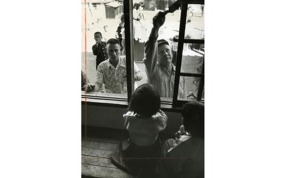 Seoul, South Korea, Oct., 1960:  Lt. Col. Fred J. Ruff and Chaplain (Maj.) William H. Briggs paint the window frames of the Sungnam Orphanage in Seoul. Lt. Col. Ruff, his wife Mrs. Annie D. Ruff and the men from the 6146th Air Force Advisory Group have been working to build a permanent home for 77 children of the Sungnam Orphanage, located south of the Han River bridge. The building is rapidly taking shape thanks to the twice-weekly visits of the Americans as officers, wives and enlisted men have contributed to the project by hefting brushes and hammers.

Pictured here is a scan of the original 1960 print created by Stars and Stripes Pacific's photo department to run in the print newspaper. The red marks indicate the crop lines. Only the middle part of the image would appear in the newspaper. As all pre-1964 Stars and Stripes Pacific negatives and slides were unwittingly destroyed by poor temporary storage in 1963, the prints developed from the late 1940s through the earlu 1960s are the only images left of Stripes' news photography from those decades. Stars and Stripes' archives team is scanning these prints to ensure their preservation. 

META TAGS: Pacific; South Korea; Korean orphan; children; orphans; girl; locals; South Korean; servicemember; construction; painting; chaplain; charity; philanthropy