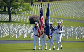 A U.S. Navy color guard present the colors at the Memorial Day ceremony at Lorraine American Cemetery in St. Avold, France, in 2023. Behind the sailors are some of the cemeterys 10,481 graves. 