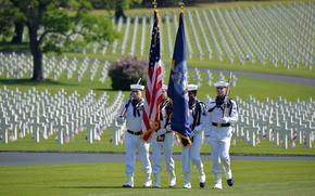 A U.S. Navy color guard present the colors at the Memorial Day ceremony at Lorraine American Cemetery in St. Avold, France, in 2023. Behind the sailors are some of the cemeterys 10,481 graves. 