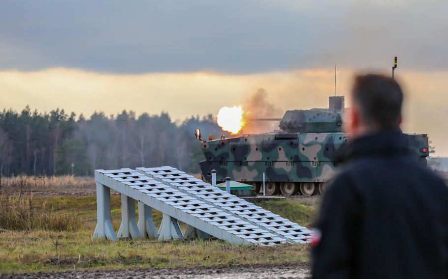 The new Polish infantry fighting vehicle, the Badger, fires its 30 mm cannon during a demonstration attended by Polish Defense Minister Mariusz Blaszczak, right, in Bemowo Piskie, Poland, Nov. 14, 2022. The Badger's modernized armor and weaponry replaces an older Soviet-era model and will support a U.S.-led NATO battlegroup responsible for defending the alliance against potential aggression from Russia.