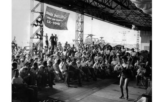 Hed: Putting on a show, 1962

Somewhere in South Vietnam, July 1962: American USO trooper Bunita Jeane dances for members of Marine Helicopter Sq. 163 during a two-day entertainment tour of the Republic of Vietnam. The USO group was headed by comedian Gene Evans and included dancers Carol Jason, banjo player Joe Chapelle and drummer Tom Wafford, all all the way from Los Angeles. 1962, date unknown.

Were you at this show? Do you know where it was and when? Let us know! https://www.stripes.com/contact/

Looking for Stars and Stripes’ coverage of the Vietnam War? Subscribe to Stars and Stripes’ historic newspaper archive! We have digitized our 1948-1999 European and Pacific editions, as well as several of our WWII editions and made them available online through https://starsandstripes.newspaperarchive.com/

META TAGS: Pacific; South Vietnam; celebrity; entertainment; performance; servicemembers; dancing; legs; audience; USO; helicopter; banner; USMC; Marines