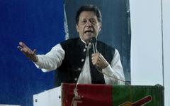 Protected by a bulletproof barrier, former Prime Minister Imran Khan speaks during a rally in Lahore, Pakistan, Sunday, March 26, 2023, to pressure the government of Shahbaz Sharif to agree to hold snap elections. (AP Photo/K.M. Chaudary)