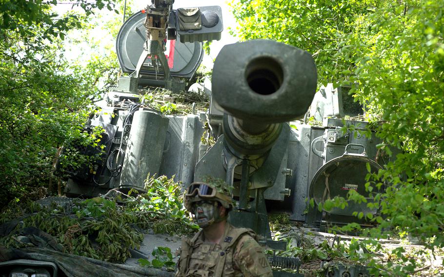A soldier camouflages their mobile artillery system during exercise Combined Resolve