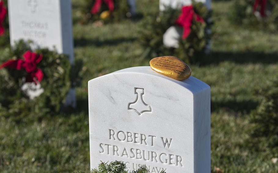 A stone with a message from mom sits atop the headstone of Navy SEAL Chief Petty Officer Robert. W. Strasburger, at Arlington National Cemetery on Saturday, Dec. 17, 2022, The stone reads “Rob, You left us many memories. Your love is still our guide. Although we cannot see you, you’re always at our side.”