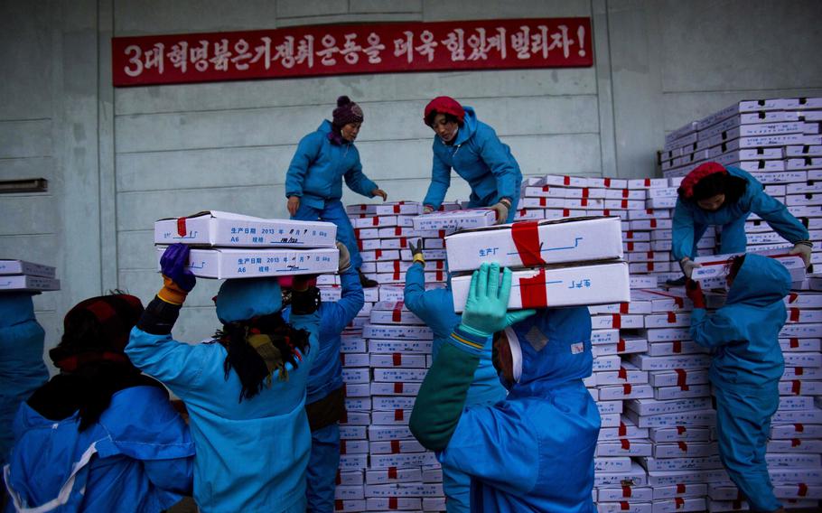 Workers carry boxes of seafood on Nov. 8, 2013, as they load a Chinese transport truck at the Suchae Bong Corp seafood factory in Rajin, North Korea, inside the Rason Special Economic Zone. China and Russia are urging the U.N. Security Council to end a host of sanctions against North Korea ranging from the export of seafood and textiles to the cap on imports of refined petroleum products and the ban on its citizens working overseas and sending home their earnings. (AP Photo/David Guttenfelder, File)