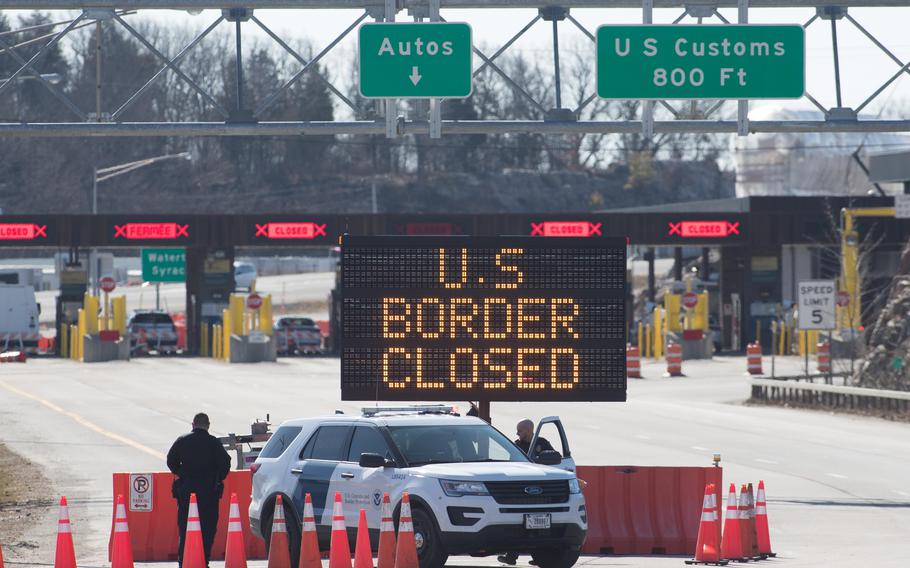 U.S. Customs officers stand beside a sign saying that the U.S border is closed at the US/Canada border in Lansdowne, Ontario, on March 22, 2020. Canada in 2022 has a problem with hospital space to meet the demands of those with COVID-19, particularly the omicron variant. 