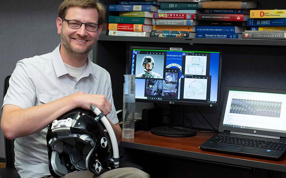 Dr. David Jesse Daily, a mechanical engineer in the Naval Undersea Warfare Center Division Newport’s Sensors and Sonar Systems Department, holds a prototype of a football helmet he designed after researching acceleration-based cavitation.