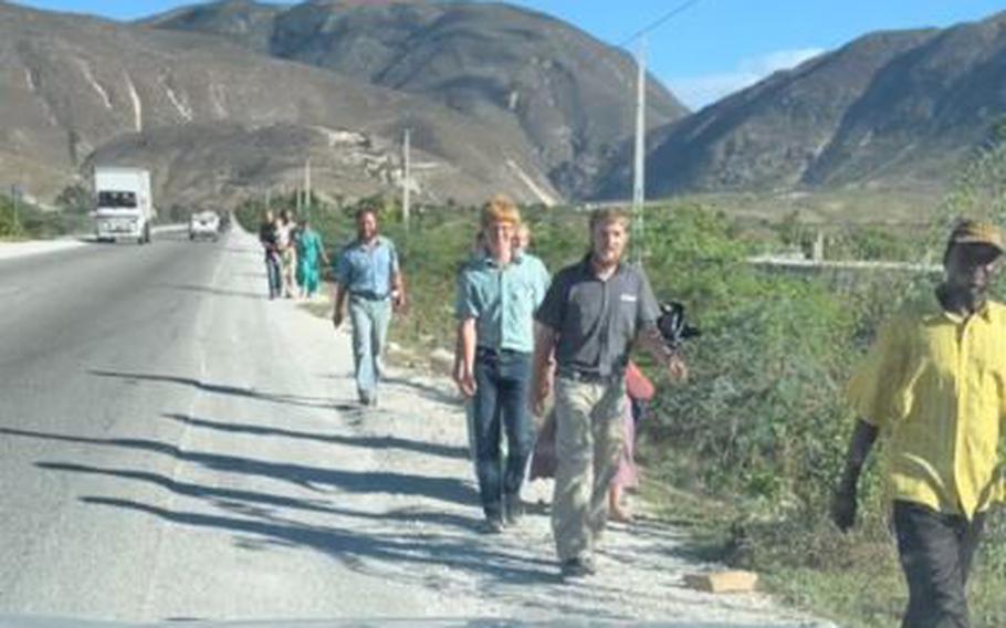 A video screen grab shows the arrival of the final 12 hostages walking along a road in Haiti on Thursday, Dec. 16, 2021, after they walked through the night to escape their captors.