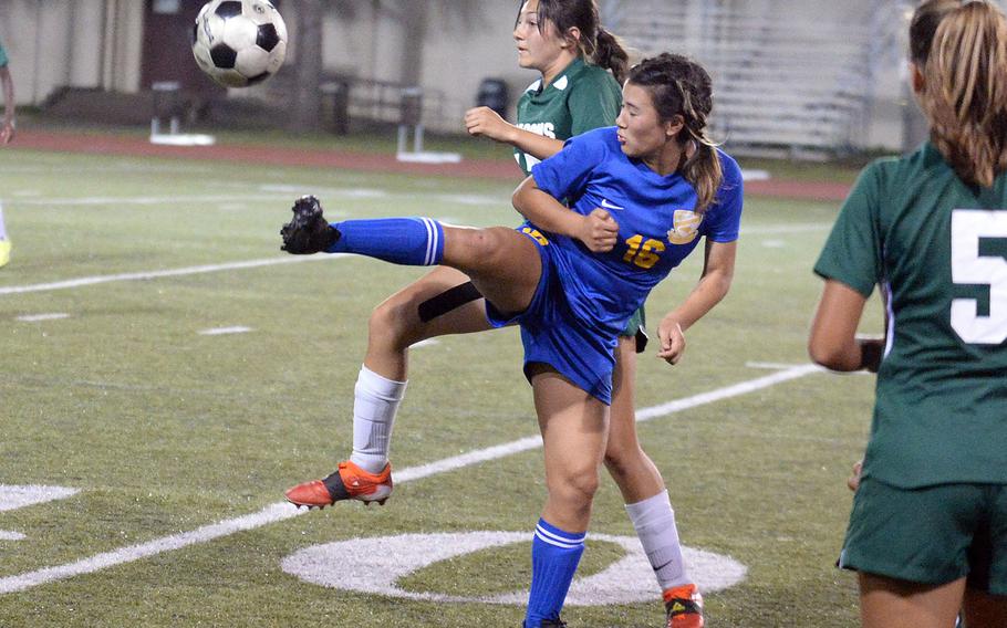 Yokota's Samantha Kozinski boots the ball away from Kubasaki's Reighlyn Kissick during Saturday's All-DODEA-Japan girls soccer tournament final. The Dragons won 4-1.