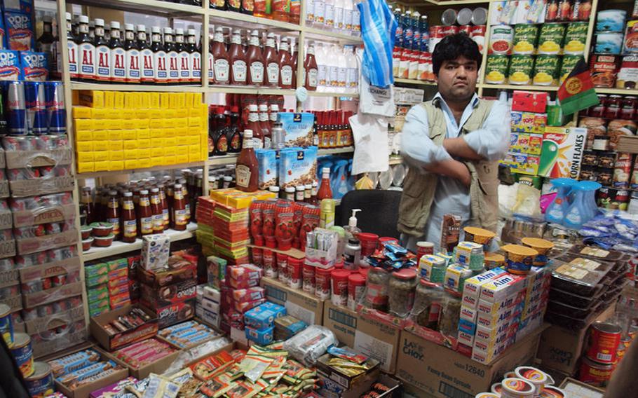 An Afghan shop owner in Kabul’s “Bush Market” stands among American products likely stolen off of American supply convoys.