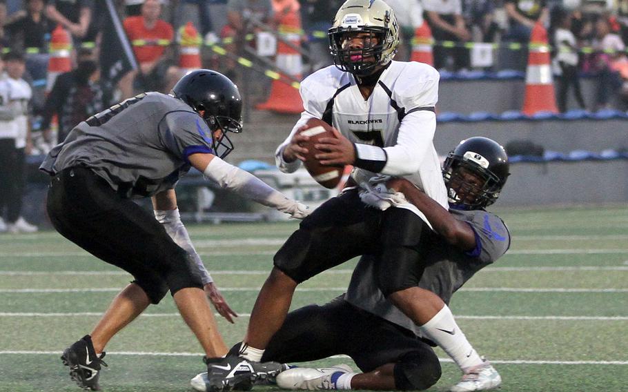 Humphreys quarterback Sean Cook gets tackled by Osan's Justiss Parker-Jones.