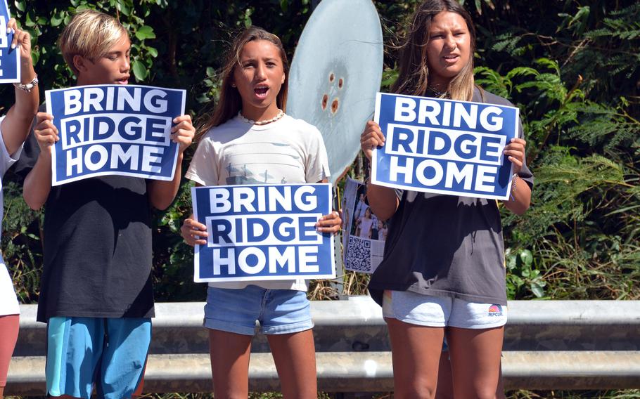 Supporters of Navy Lt. Ridge Alkonis, sentenced this summer to three years in a Japanese prison, beckon to vehicles entering and exiting Camp H.M. Smith in Honolulu, Wednesday, Aug. 31, 2022.