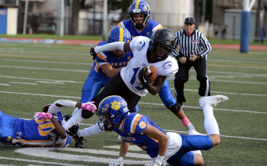 Osan's Aaron Patterson gets wrestled down by several Yokota defenders.