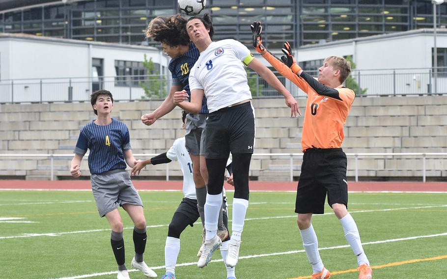 Brussels center back Matej Marinkovic beats Ansbach's Deveon Browne to a ball in the box during pool-play action May 16, 2023, at Kaiserslautern High School in Kaiserslautern, Germany. Brigand goalkeeper Yulian Tolkachov, right, tries to reach the ball as well.