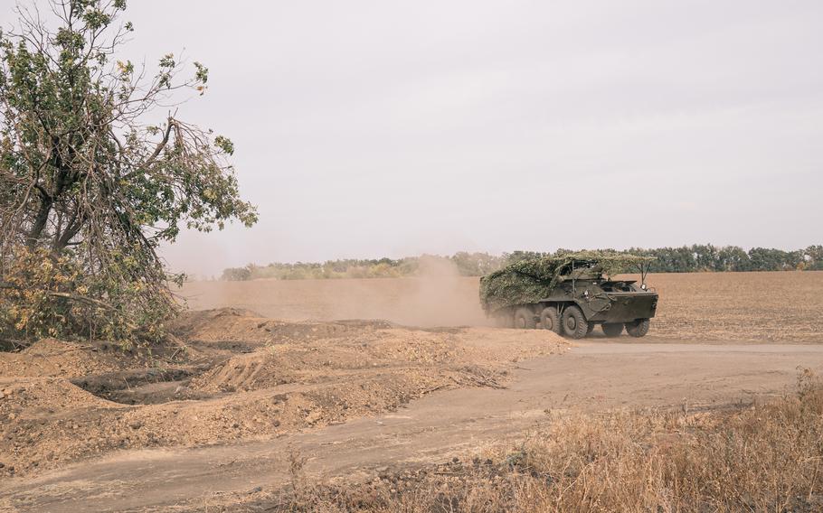 An armored vehicle kicks up dust.