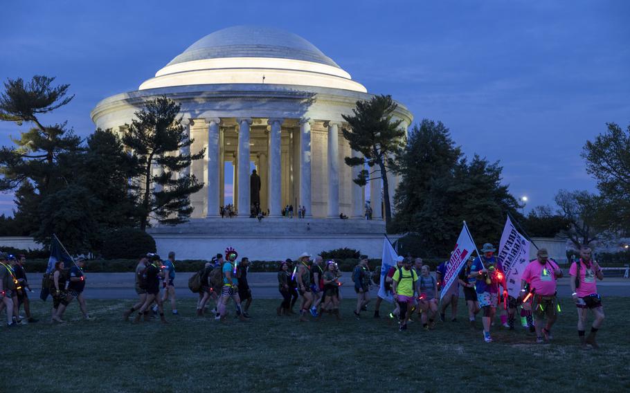 A group of hikers walk in front of the Jefferson Memorial