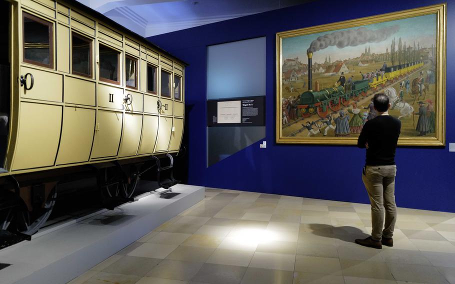 A visitor examines a depiction of the inaugural journey of the Adler at the Deutsche Bahn Museum in Nuremberg, Germany, Dec. 20, 2023. Germany's first steam locomotive was a sensation at the time, even though it traveled a mere 4 miles from Nuremberg to nearby Fuerth.
