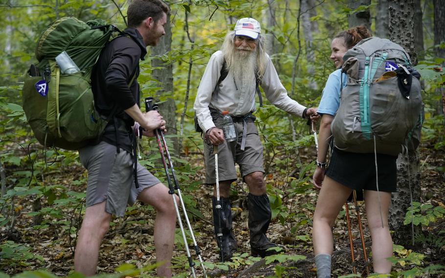 M.J. Eberhart, 83, center, shares trail information with a pair of thru-hikers on the Appalachian Trail, Sunday, Sept. 12, 2021, in Gorham, N.H. 