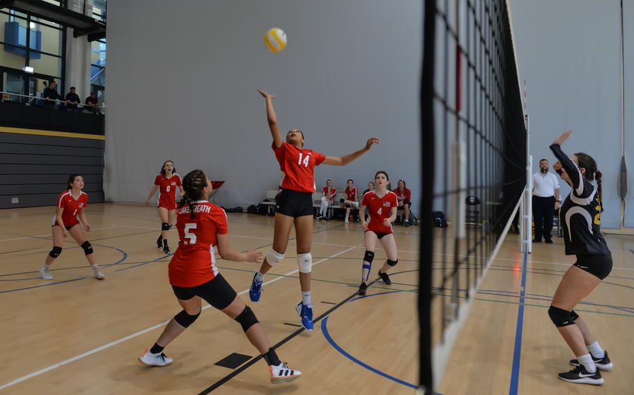 Lakenheath’s A’lydia McNeal jumps to spike the ball during the 2022 DODEA-Europe Volleyball Tournament as her teammates Joraika Rodriguez, left, and Olivia Bouchard prepare to assist, Thursday, Oct. 27, 2022, at Ramstein Air Base, Germany. Across the net, Stuttgart’s Ainsley Baker prepares to block the shot.
