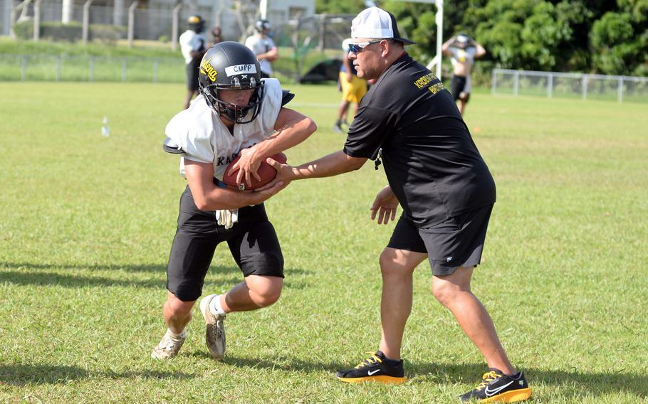 Kadena junior running back Sean Cupp takes a handoff from assistant coach Frank Macias during Monday's practice. Cupp is the son of Kadena's 18th Wing Chief Master Sgt. Will Cupp, a Panthers assistant coach.