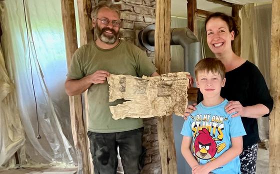 Niko und Franziska Foerster, with their oldest son Karl, and the Stars and Stripes newspaper they found in wall of their home recently in Rohren, Germany.