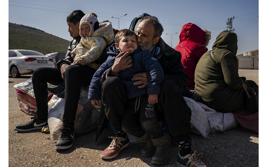 Ahmed Soleiman, 52, hugs a grandchild as his family waits Thursday at the crossing. Soleiman’s youngest daughter was a child about the age of this one when she left Syria nine years ago. 