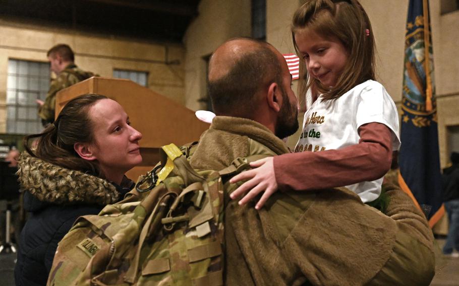 Mehmet Tulunbike reunites with wife, Kirsten, and daughter, Sierra, at a welcome home ceremony for the 3rd Battalion, 197th Field Artillery Regiment on Feb. 8, 2024, at the Manchester, N.H., armory.