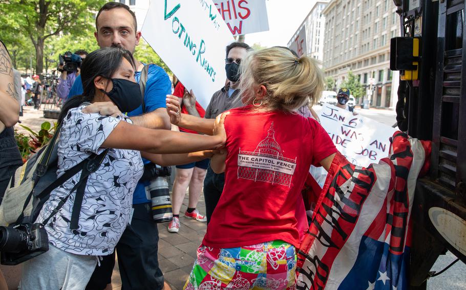 Pro and anti-Trump activists scuffle outside of the Department of Justice in Washington, on July 27, 2021, after a news conference over the treatment of people detained during the Jan. 6 riot.