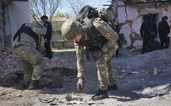 A police officer examines fragments of a guided bomb after the Russian air raid in Kharkiv, Ukraine, on April 30, 2024.