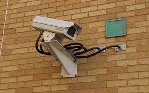 A security camera installed on a brick wall.