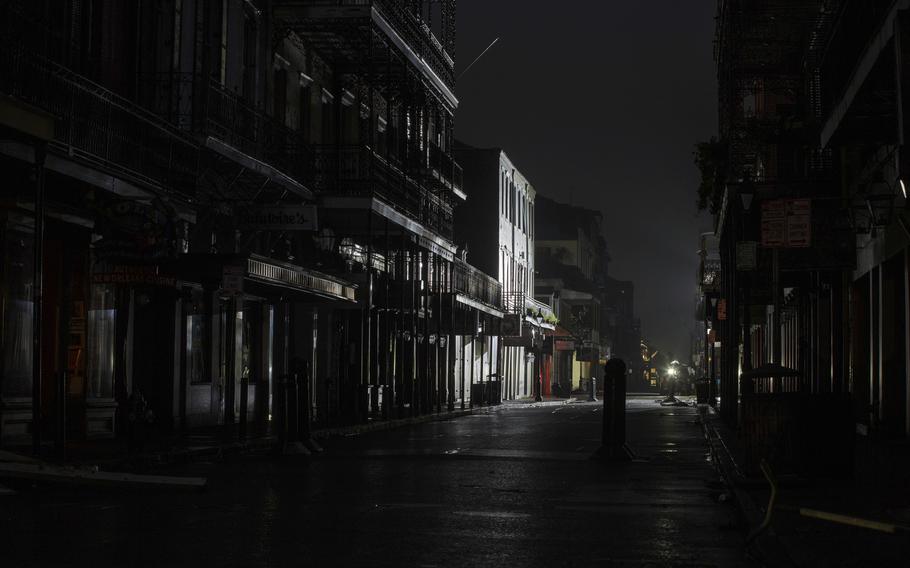 Bourbon Street in the New Orleans French Quarter is dark except for lights used during a TV broadcast Monday, Aug. 30, 2021, after New Orleans lost power during Hurricane Ida. 