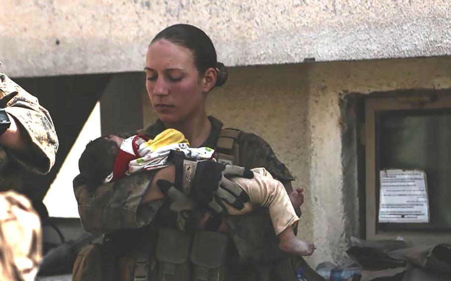 A U.S. Marine holds a baby.