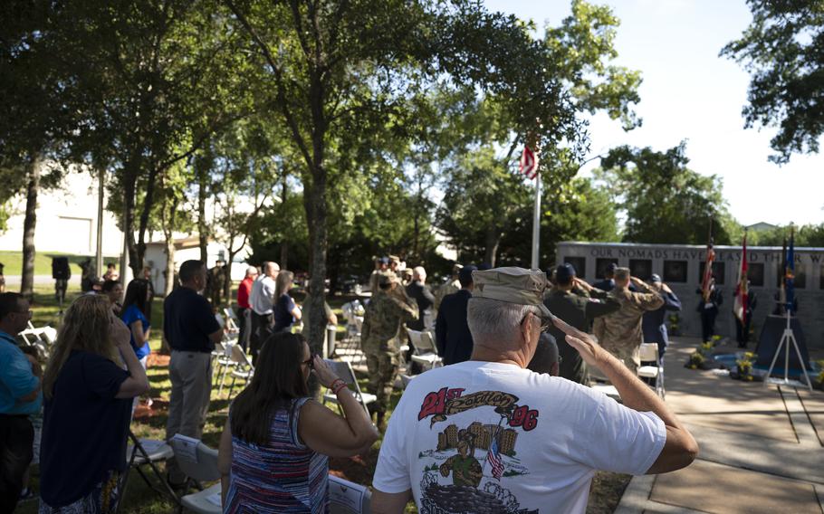 Attendees of the Khobar Towers 25th Annual memorial ceremony salute during the playing of the national anthem, June 25, 2021, at Eglin Air Force Base, Florida. Nineteen Airmen were killed and more than 400 other military personnel and civilians were injured in the blast. 