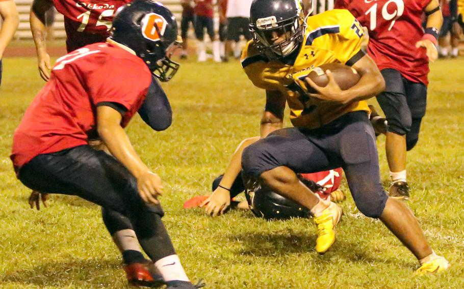 Guam High's DeShawn Baird looks for running room against Okkodo's John Perez.