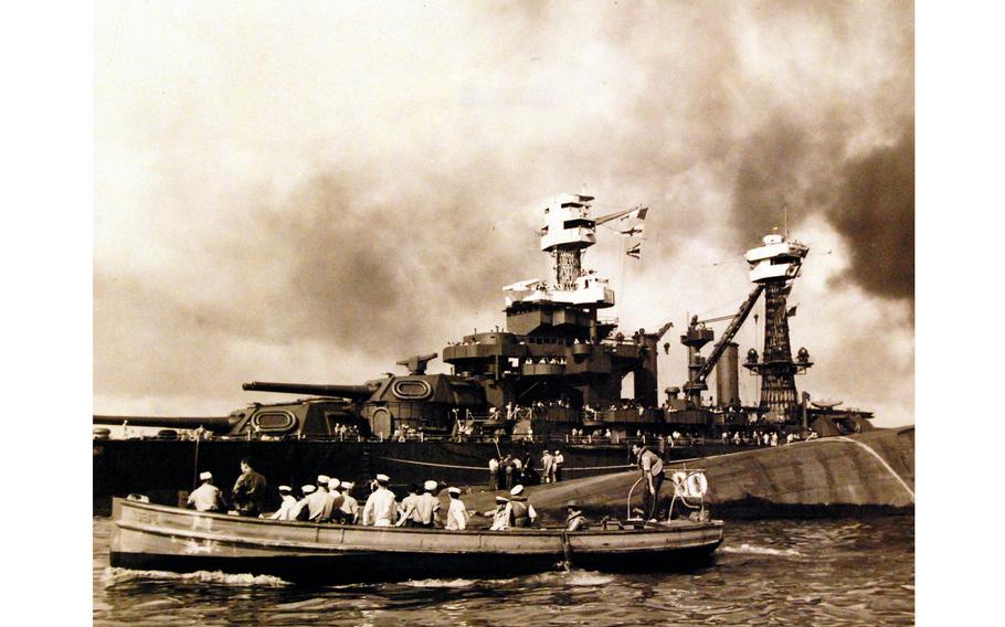 View of "Battleship Row" during or immediately after the Japanese attack on Pearl Harbor on Dec. 7, 1941. The capsized USS Oklahoma is in the center, alongside the USS Maryland. 