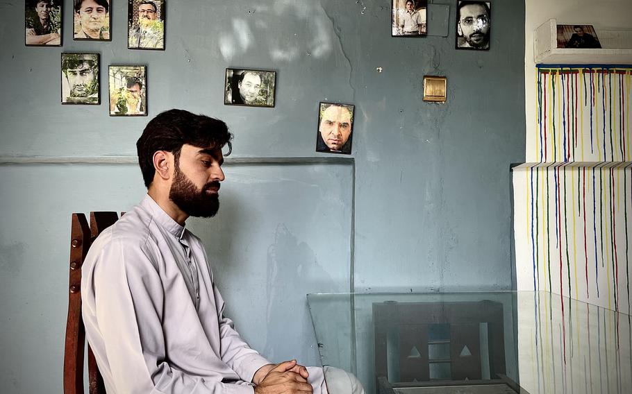 Rohullah Raziqi sits in front of a wall of photos of inspirational figures at a cafe run by a friend that also serves as an art space and bookstore where activists have been gathering before setting out for protests. Raziqi says the Taliban forced the cafe's owners to take down photos of women, leaving only men's photos on the wall. 
