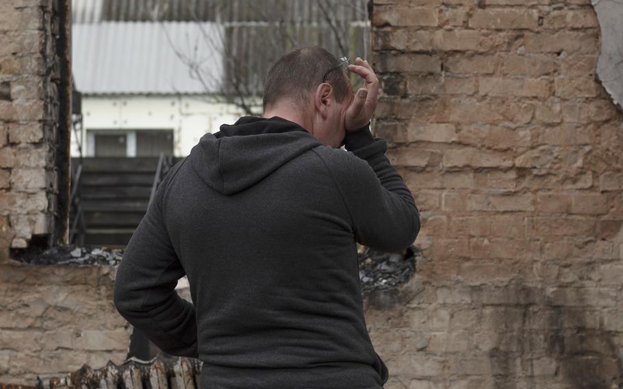 Vadym Zherdetsky reacts standing in the remains of his destroyed house, in the village of Moshun, outside Kyiv, Ukraine, Nov. 4, 2022. 