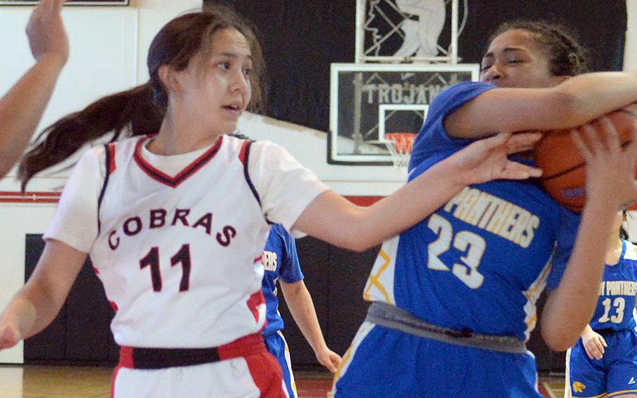 Yokota's Christina Smith snags the ball away from E.J. King's Maliwan Schinker during Friday's DODEA-Japan girls basketball tournament semifinal. The Cobras won 51-13 and will face Nile C. Kinnick in Saturday's final.