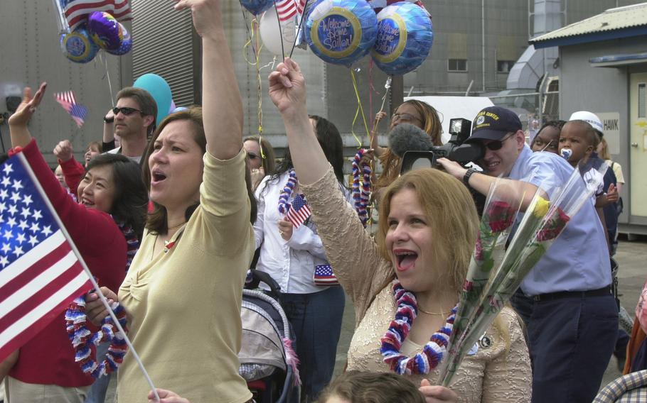 Family members of the sailors from USS Kitty Hawk cheer as they “man the rails” upon the ship’s return from a deployment to the Persian Gulf.