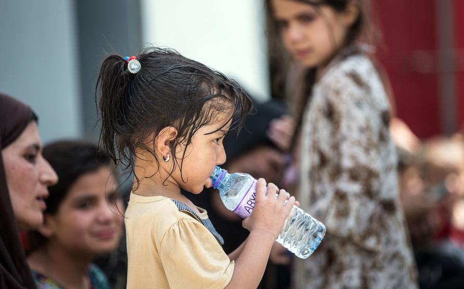 An Afghan child sips water at Hamid Karzai International Airport in Kabul, Afghanistan, Aug. 20, 2021.