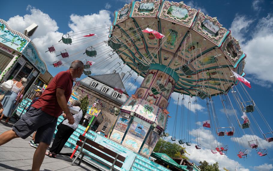 A man walks past a nearly empty ride at the fair in Wittlich, Germany, on Monday, Aug. 21, 2023. Attendance at the annual event has been low since a man was stabbed to death Saturday, workers say.