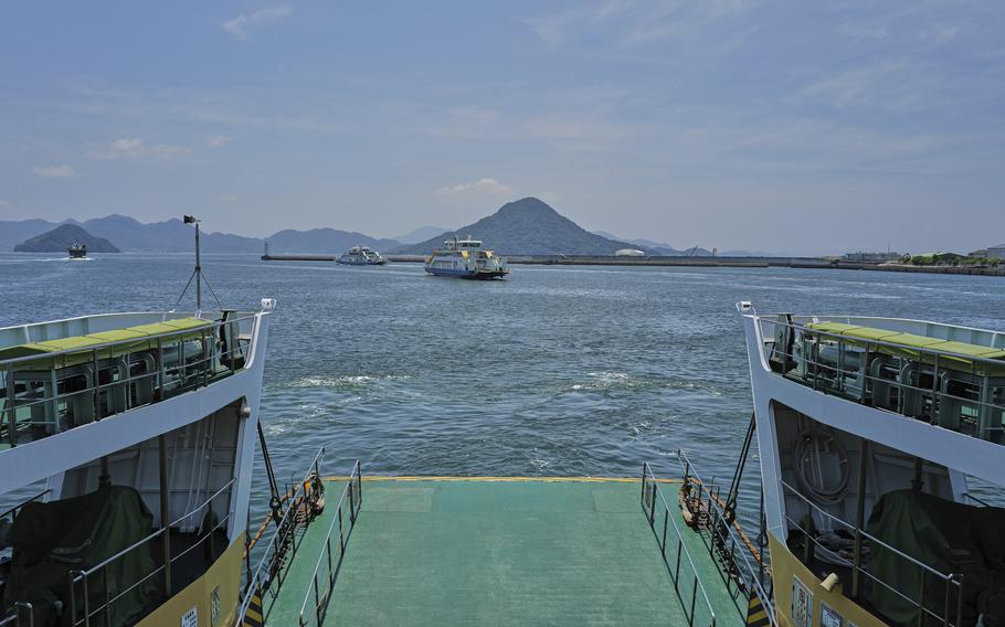 A green island is seen in blue waters.