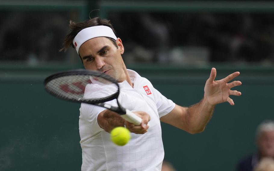 Switzerland’s Roger Federer hits a return to Poland’s Hubert Hurkacz during their men’s singles quarterfinal on July 7, 2021 at Wimbledon. Federer announced Thursday he is retiring from tennis.