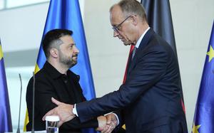 German Chancellor Friedrich Merz, right, and Ukrainian President Volodymyr Zelenskyy, left, shake hands after a joint press statement following talks with European and U.S. leaders in Berlin, Germany, Wednesday, Aug. 13, 2025. (AP Photo/Ebrahim Noroozi)