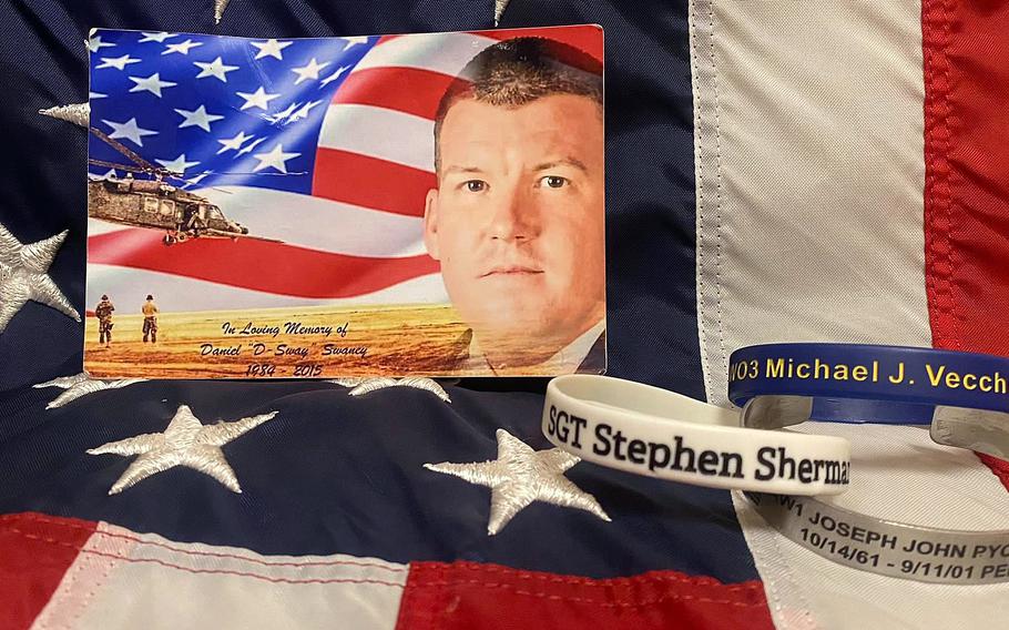 A photograph of Tech. Sgt. Daniel Swaney rests on an American flag, along with bracelets from Gold Star families. In 2019, Master Sgt. Trevor Derr met with a team from the New Jersey Run for the Fallen, an organization of military runners and support crew who run one mile for each New Jersey service member who has died during the U.S. war on terror. Derr runs to honor Swaney, who died by suicide in 2015, and others.